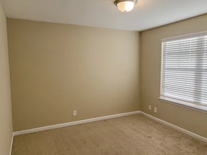 an empty room with windows and closet