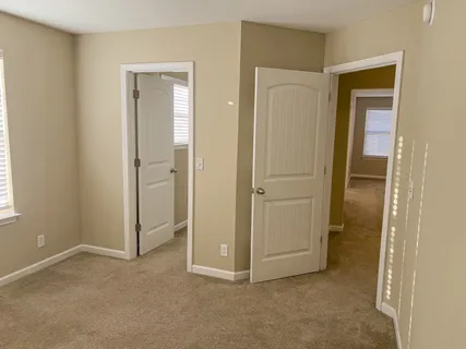 an empty room with closet and a bathroom