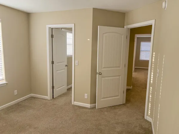 an empty room with closet and a bathroom