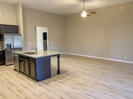 a kitchen with stainless steel appliances granite countertop a sink dishwasher a stove with wooden floors