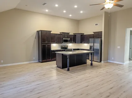 a kitchen with stainless steel appliances granite countertop a stove a sink and a refrigerator