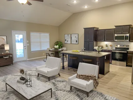 a living room with furniture and kitchen view