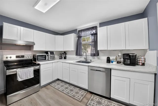 a kitchen with granite countertop white cabinets and white appliances