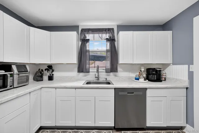 a kitchen with white cabinets and appliances