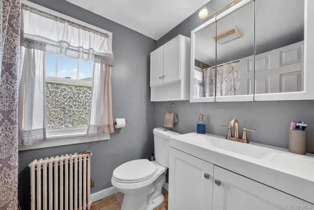 a bathroom with a sink a toilet and a window