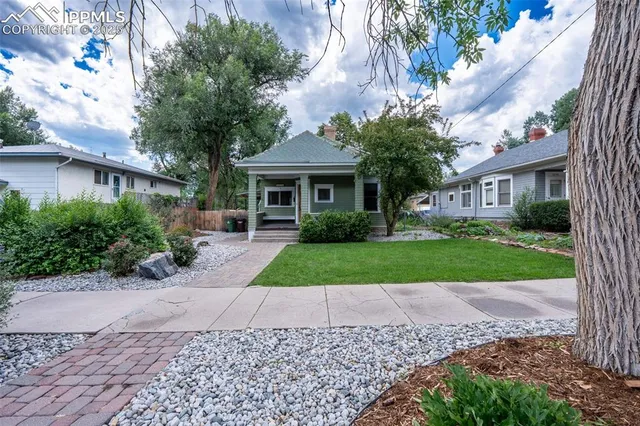 a front view of a house with a yard and potted plants