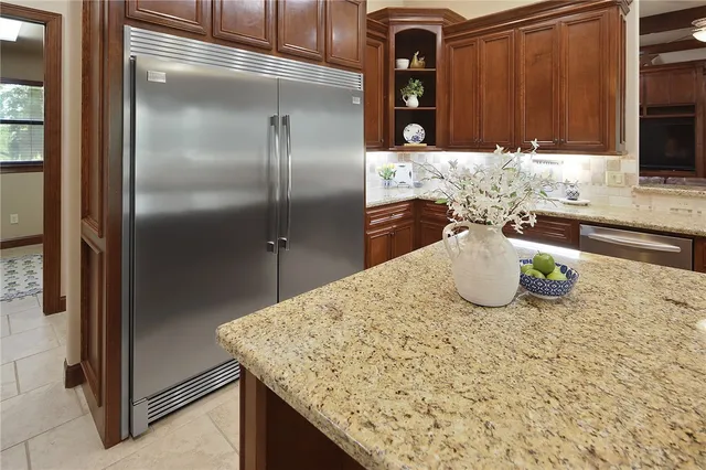 a kitchen with a granite counter top and a refrigerator