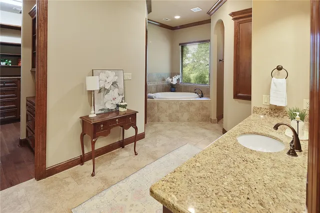 a spacious bathroom with a tub sink and mirror