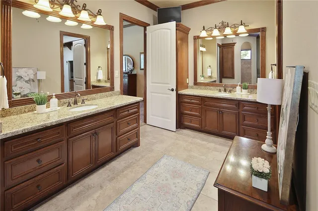 a bathroom with a granite countertop double vanity sink and a mirror