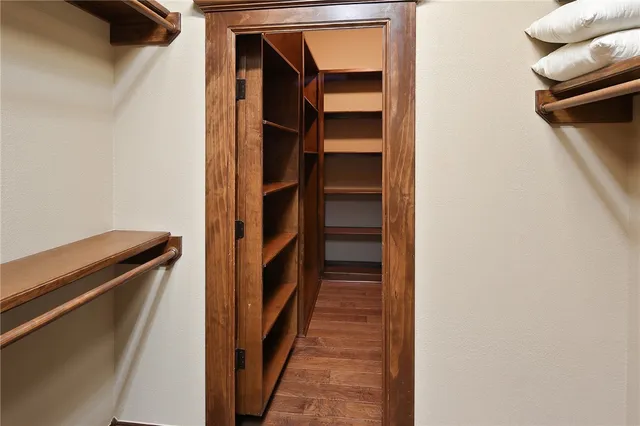 a view of walk in closet with clothes and shoes