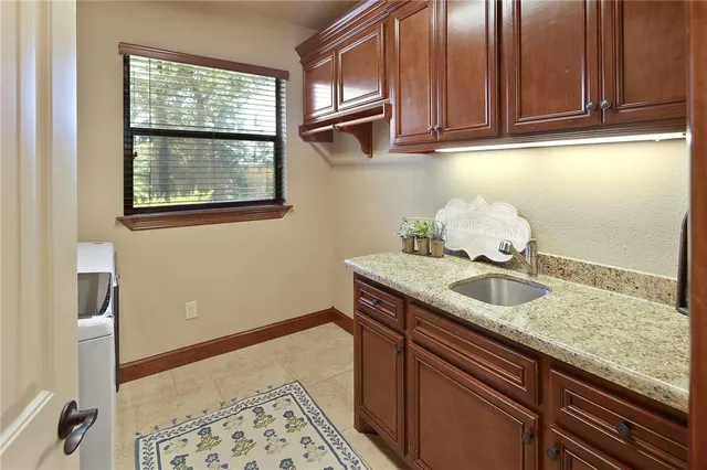 a bathroom with a granite countertop sink and a window