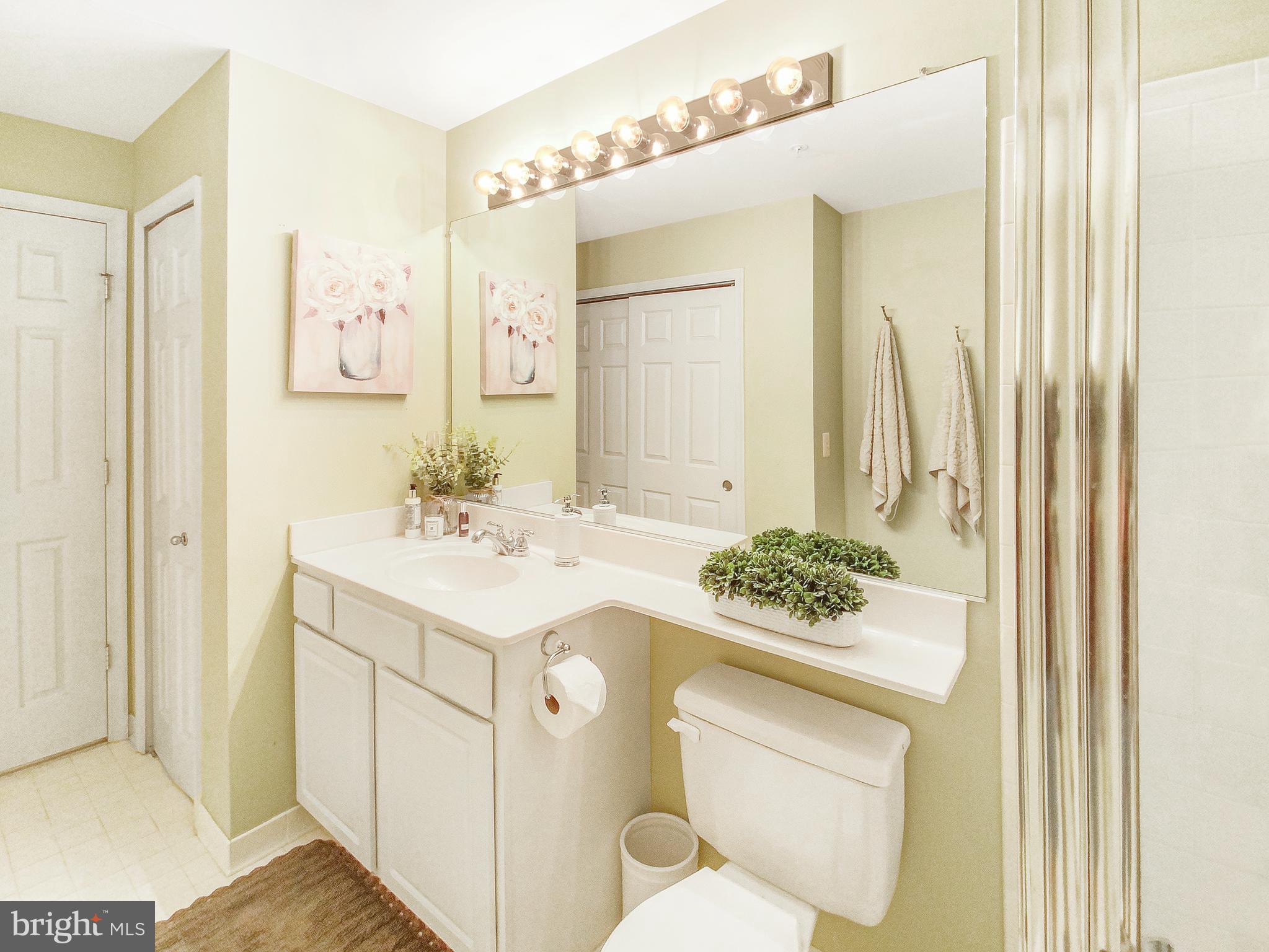 127 Timberbrook Lane, Unit 203 Gaithersburg, MD 20878 - Photo 16 of 29 a bathroom with a granite countertop sink a toilet and a mirror