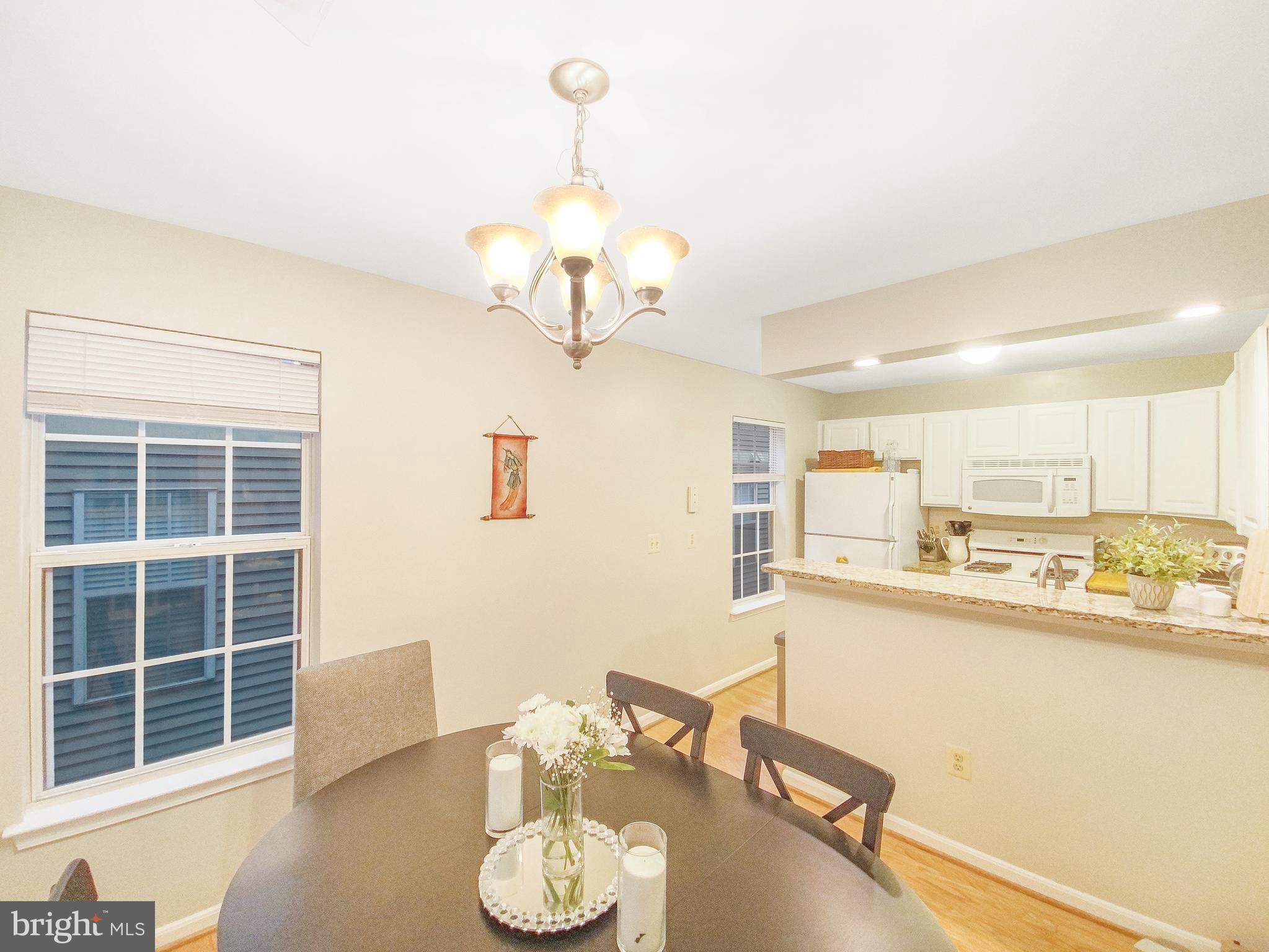 127 Timberbrook Lane, Unit 203 Gaithersburg, MD 20878 - Photo 23 of 29 a view of a dining room with furniture a chandelier and a large window