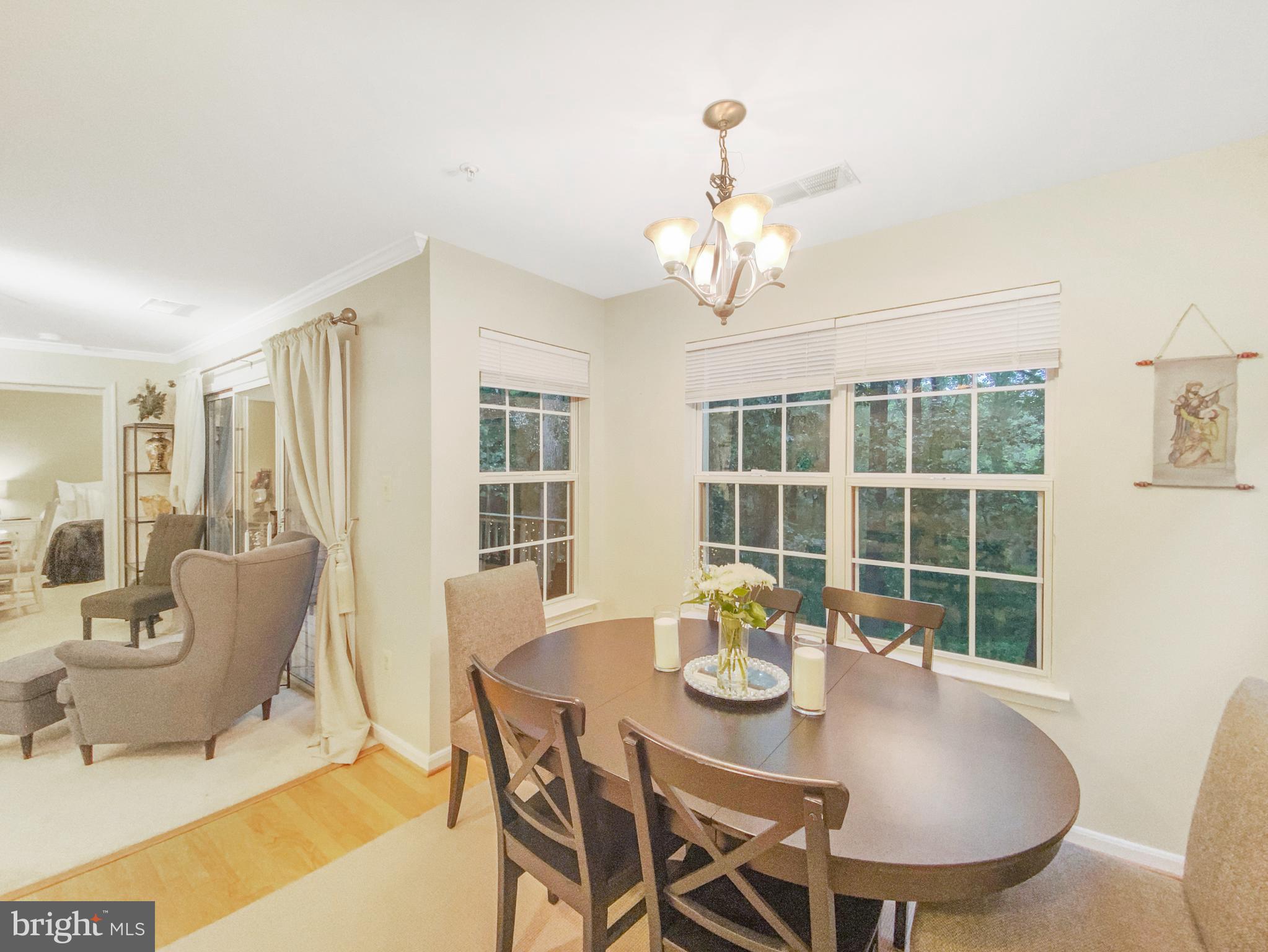 127 Timberbrook Lane, Unit 203 Gaithersburg, MD 20878 - Photo 24 of 29 a view of a dining room with furniture wooden floor and chandelier