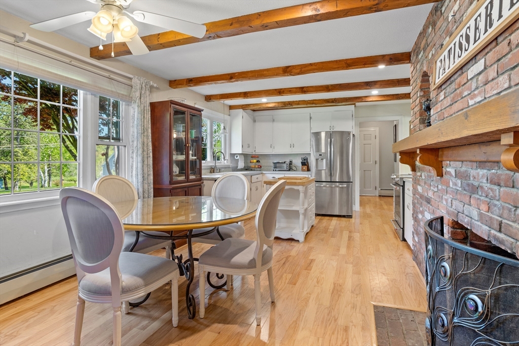 717 George Hill Road Lancaster, MA 01523 - Photo 14 of 36 a dining room with furniture a fireplace a rug and a chandelier