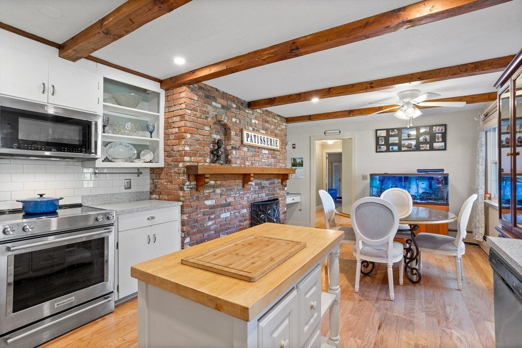 717 George Hill Road Lancaster, MA 01523 - Photo 20 of 36 a kitchen with stainless steel appliances granite countertop a stove top oven a sink a dining table and chairs
