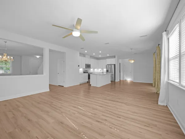 a bedroom with a bed chandelier and a window