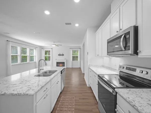 a view of an empty room with wooden floor fireplace and a window