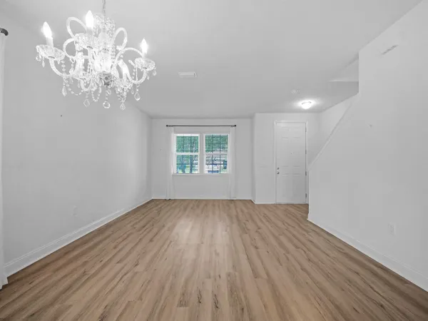 a view of a kitchen with a refrigerator wooden floor and a sink