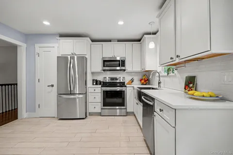 a kitchen with a refrigerator a stove and a sink