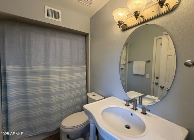 a bathroom with a sink a toilet and mirror