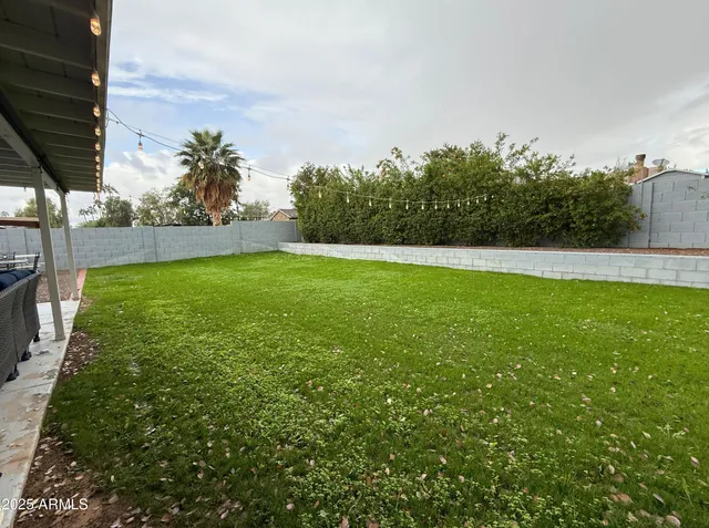 a view of yard with swimming pool and trees in the background