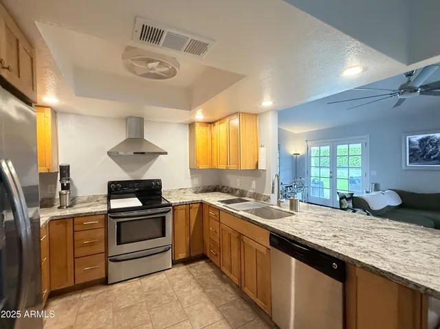 a kitchen with stainless steel appliances granite countertop a sink stove and refrigerator