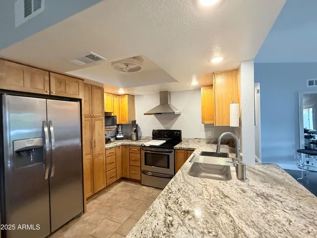 a kitchen with stainless steel appliances granite countertop a sink stove and refrigerator