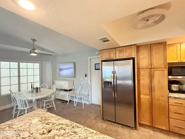 a kitchen with stainless steel appliances granite countertop a refrigerator and a sink