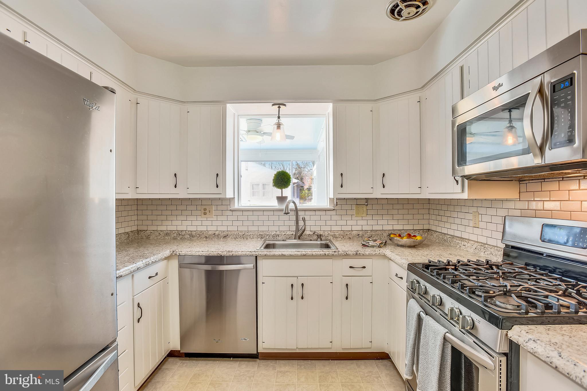 7308 Foxe Place Springfield, VA 22151 - Photo 11 of 38 a kitchen with white cabinets appliances and a window