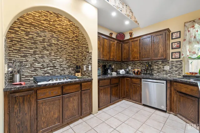 a kitchen with stainless steel appliances granite countertop a sink and cabinets
