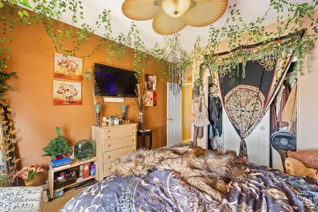 a bed sitting in a bedroom next to a lamp