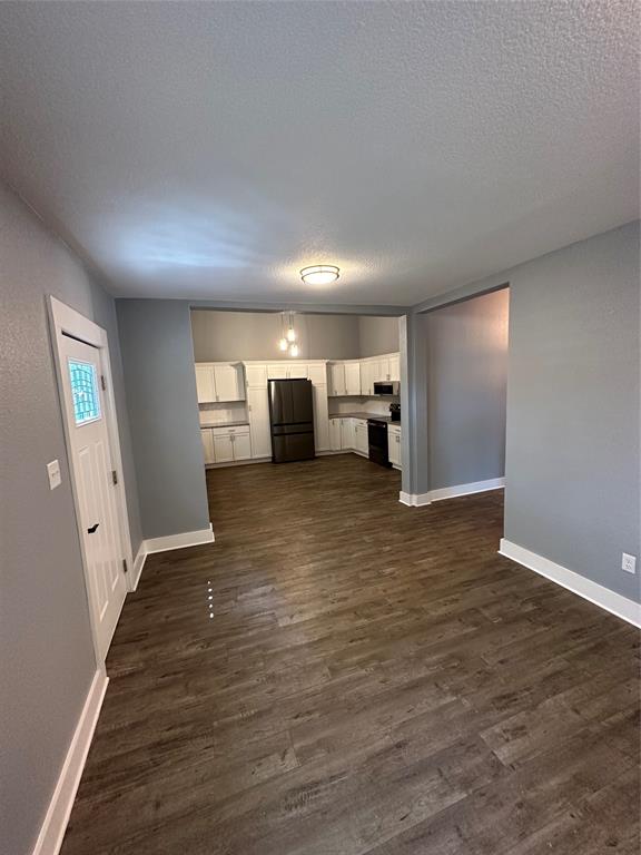 605 South Fordyce Street Blooming Grove, TX 76626 - Photo 11 of 30 a view of a big room with wooden floor and windows