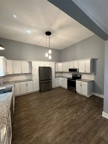 a large kitchen with stainless steel appliances kitchen island a large counter top and stove top oven