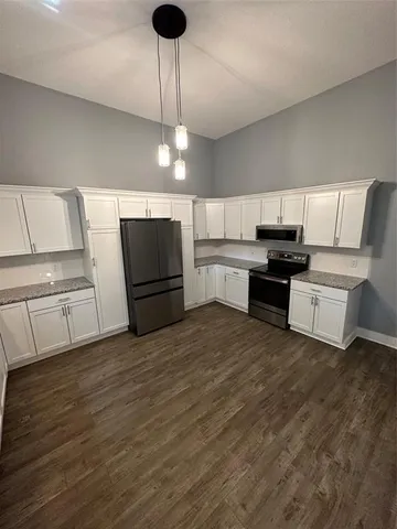 a kitchen with stainless steel appliances a stove refrigerator and cabinets