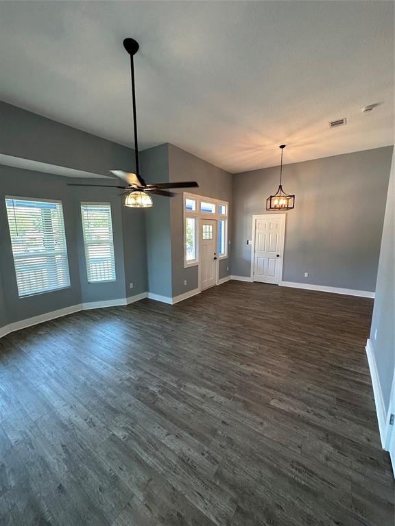 605 South Fordyce Street Blooming Grove, TX 76626 - Photo 8 of 30 a view of an empty room with wooden floor and a ceiling fan