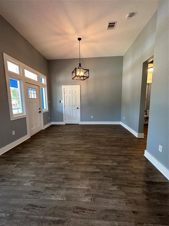 605 South Fordyce Street Blooming Grove, TX 76626 - Photo 9 of 30 an empty room with wooden floor and windows
