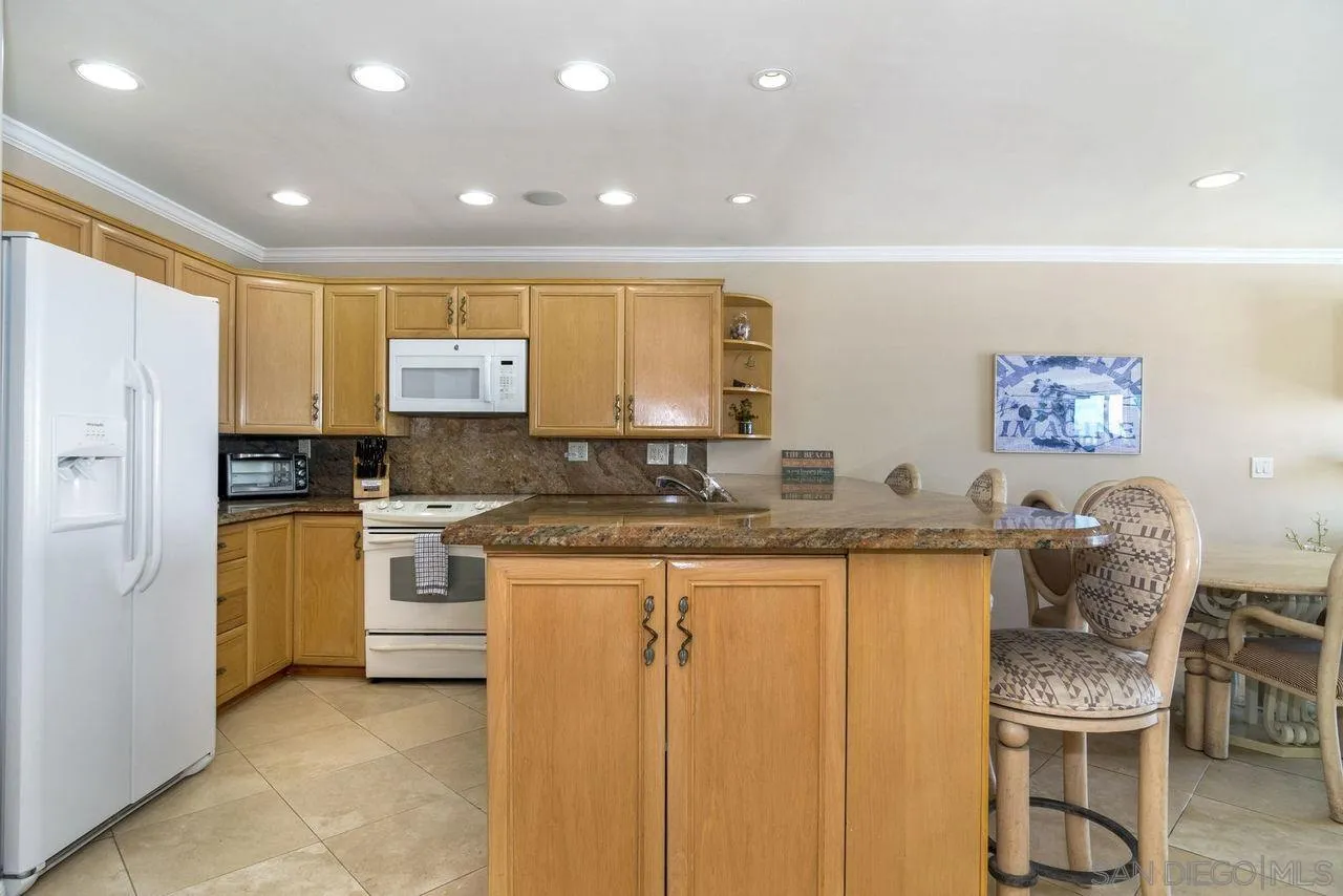 833 Beach Front Drive, Unit C Solana Beach, CA 92075 - Photo 11 of 25 a kitchen with granite countertop a sink stove and refrigerator