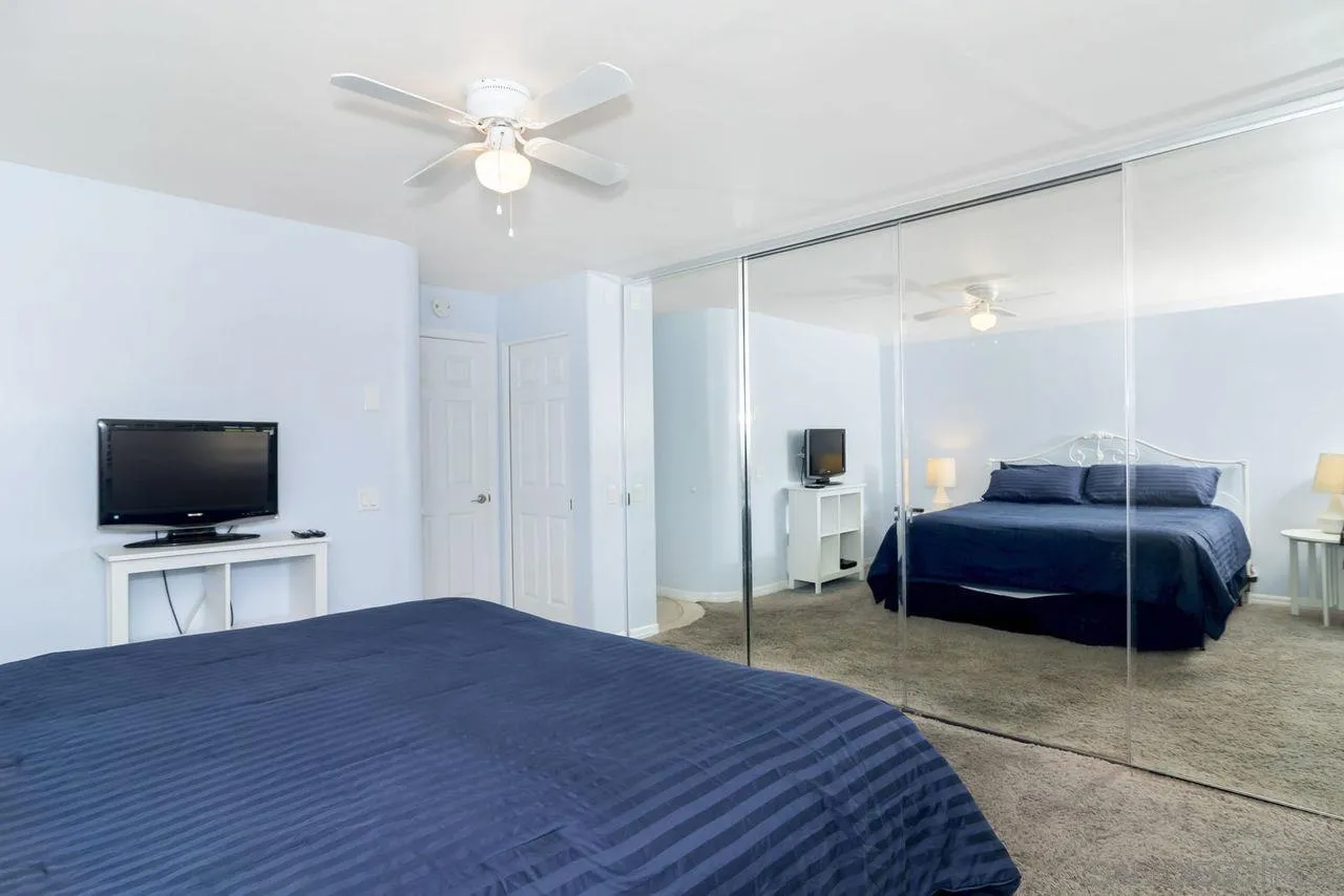 833 Beach Front Drive, Unit C Solana Beach, CA 92075 - Photo 14 of 25 a spacious bedroom with a bed and a flat screen tv