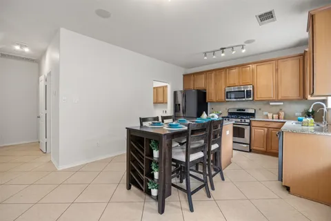 a kitchen with stainless steel appliances a stove a sink refrigerator and a microwave