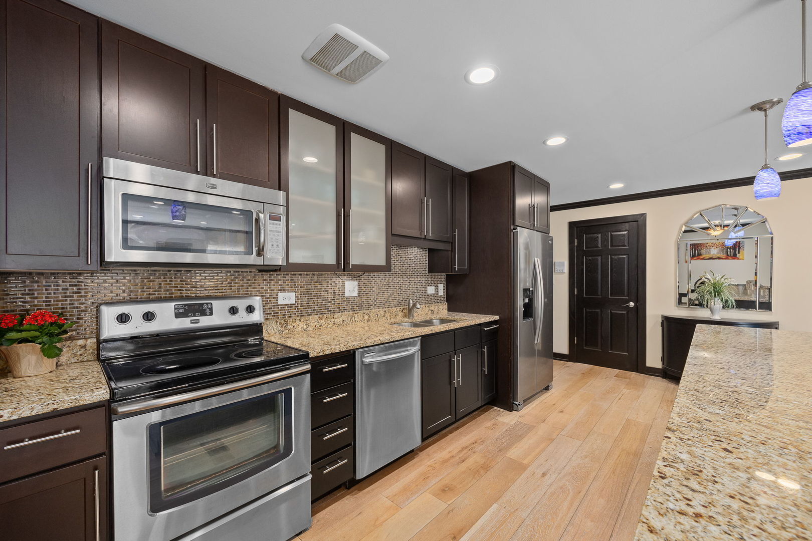 140 Carriage Way Drive, Unit C218 Burr Ridge, IL 60527 - Photo 11 of 33 a kitchen with stainless steel appliances kitchen island granite countertop a stove cabinets and refrigerator