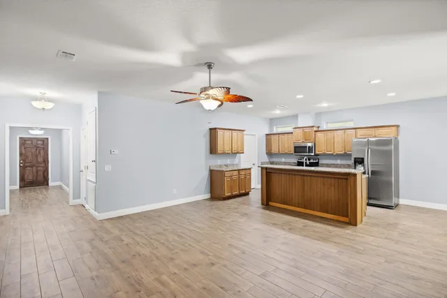 a kitchen with a refrigerator and a stove top oven