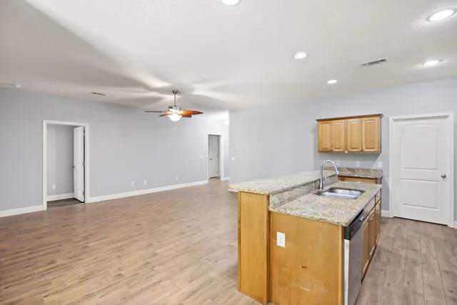 a view of a kitchen with a sink cabinets and wooden floor
