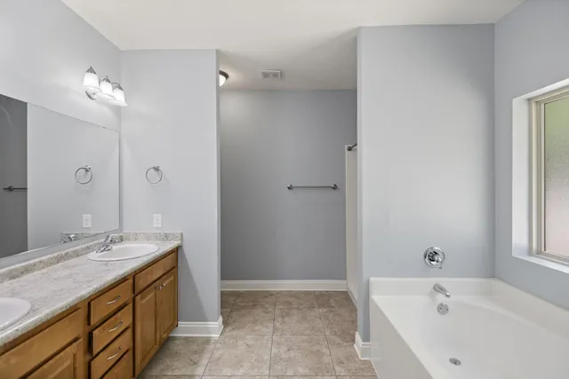 a bathroom with a tub sink and mirror