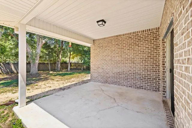 a patio with a table and chairs under an umbrella