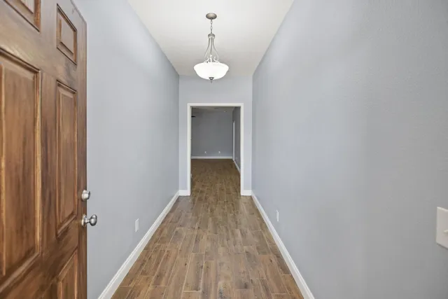 a view of a hallway with wooden floor and a large window