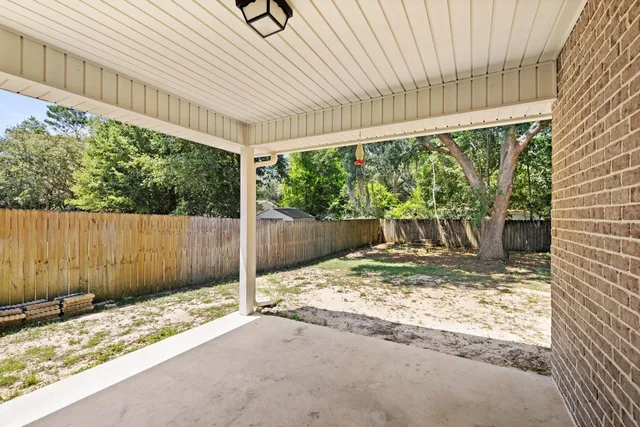 a view of a house with backyard and a tree