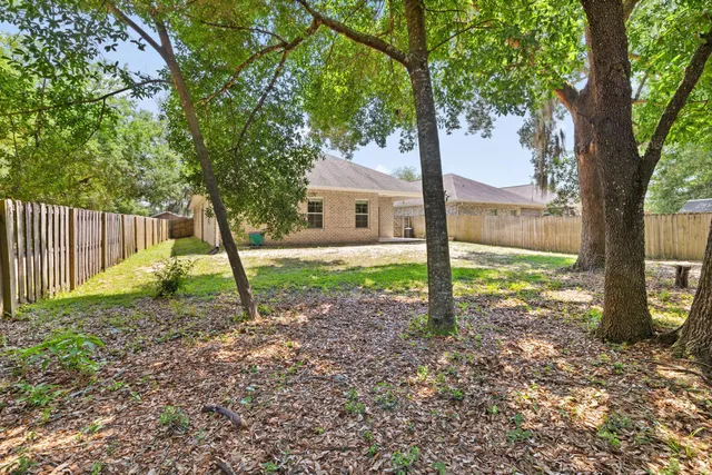 a view of a yard with wooden fence