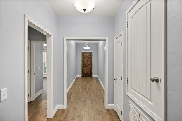 a view of a hallway with wooden floor and closet area