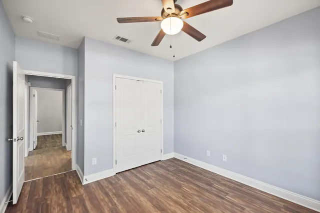 wooden floor in an empty room with a fan
